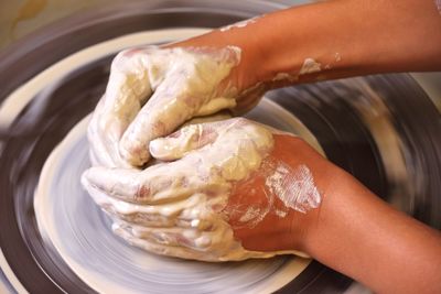 Close-up of person working on pottery wheel