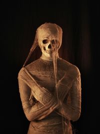 Mummy with skull over black background