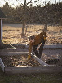 Woman digging in raised garden bed