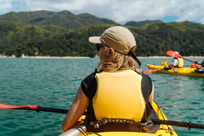 Rear view of senior woman in boat against sea