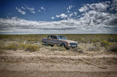 Car parked on land against sky