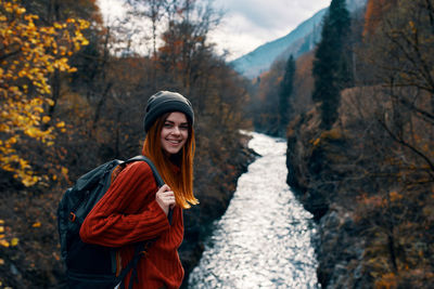 Young woman smiling in forest during autumn