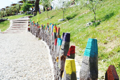 Colorfull wooden fence sticks beside pathway