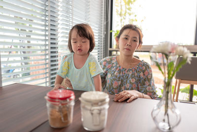 Mother and daughter sitting at table in restaurant 