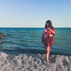 Full length of woman on beach against clear sky