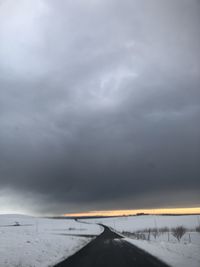 Road against cloudy sky during winter