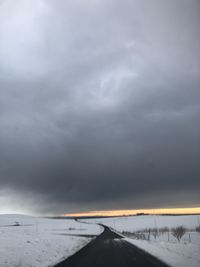 Road against cloudy sky during winter