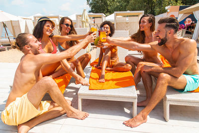 Cheerful friends toasting drinks during vacations
