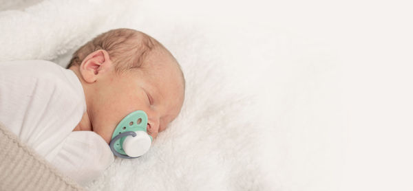 Cute baby boy sleeping on bed at home