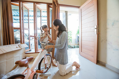 Woman standing by window at home