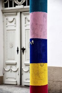 Close-up of colorful fabrics wrapped on pole against house