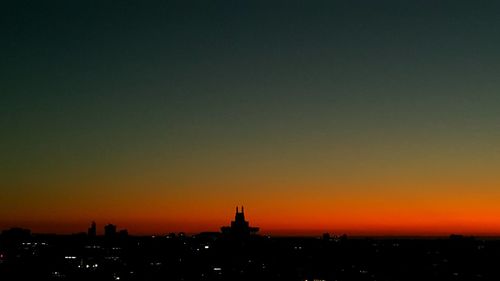 Silhouette buildings against sky during sunset