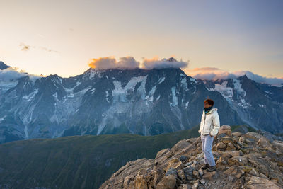 Full length of woman standing on mountain against sky