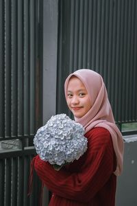 Portrait of a smiling young woman holding flowers