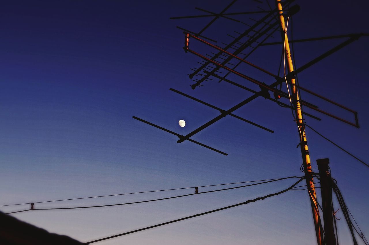 low angle view, clear sky, power line, electricity, cable, fuel and power generation, power supply, technology, silhouette, connection, electricity pylon, blue, copy space, sky, outdoors, dusk, lighting equipment, power cable, no people, day