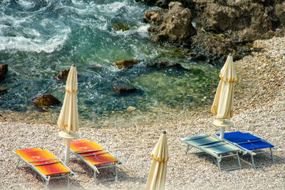 High angle view of deck chairs on rocks at beach