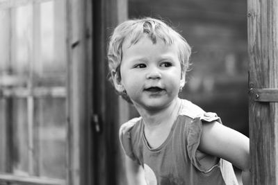 Cute baby girl looking away while standing outdoors