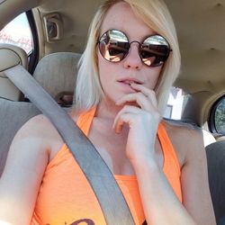 Young woman wearing sunglasses sitting in car