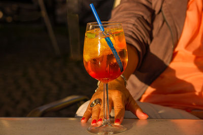 Hand of woman with drink on table