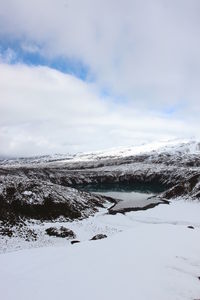 Scenic view of snow covered land against sky