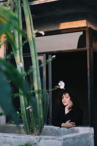 Portrait of young woman out the window at sunset