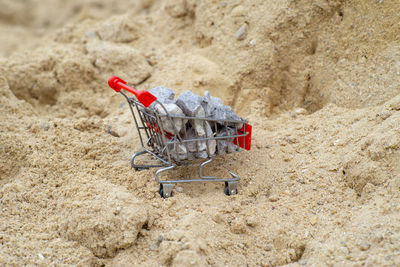 Selective focus on shopping trolley carries the crushed stones on the pile of sand at the site