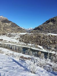 Scenic view of mountains against clear blue sky