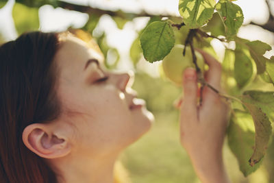 Close-up portrait of woman holding plant