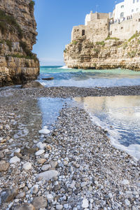 Surface level of rocks on beach against sky