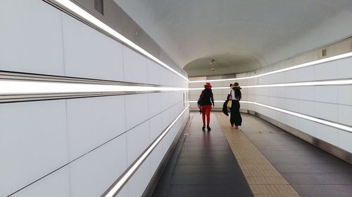 Rear view of women walking in subway