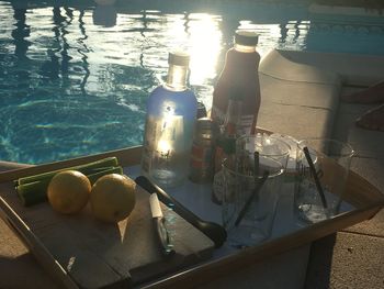 High angle view of bottles on table by swimming pool