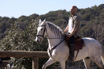 Full length of man riding horse outdoors