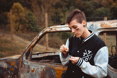 Full length of young man standing on car