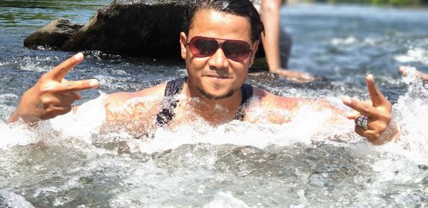 Portrait of smiling man gesturing in sea