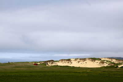 Distant view of countryside landscape against cloudy sky