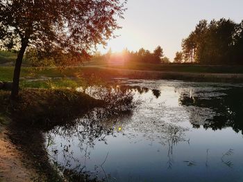 Scenic view of lake against sky at sunset