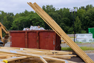 Stack of wood on field against sky