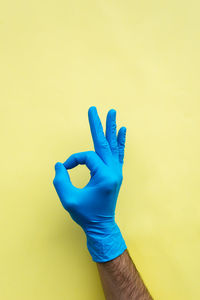 Close-up of hand against blue background