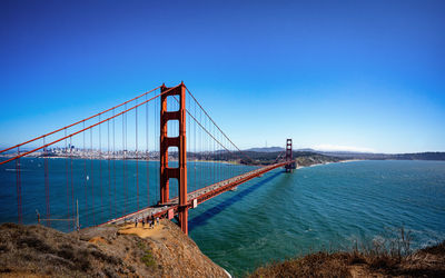 View of suspension bridge against blue sky