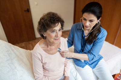 Friends sitting on bed at home