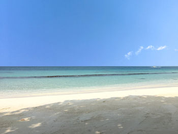 Scenic view of beach against blue sky