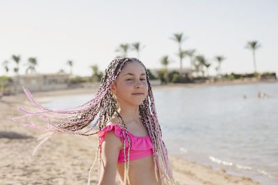 Girl with braided hair standing on shore at beach