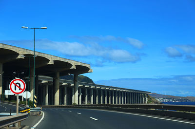 Road by bridge against sky