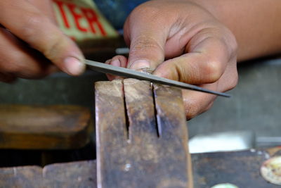 Cropped image of hand cutting wood