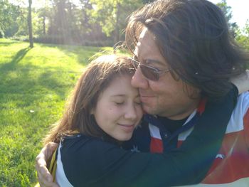 Girl embracing father on field in park