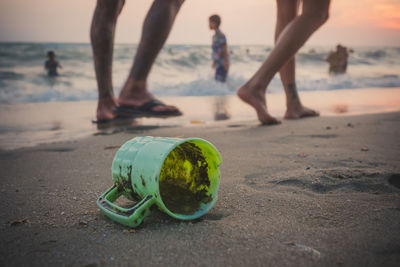 Broken mug at beach during sunset