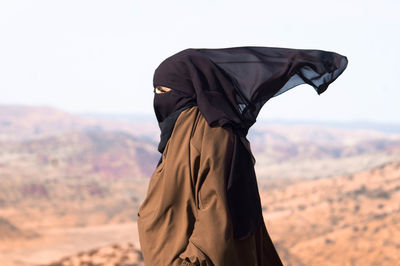 Side view of woman in hijab against sky