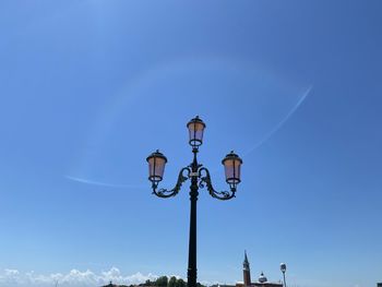 Low angle view of street light against blue sky