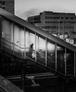 Train at railroad station in city against sky