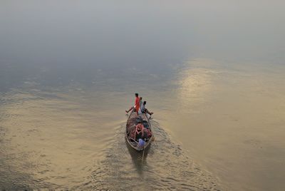 Rear view of people enjoying boat ride in river 